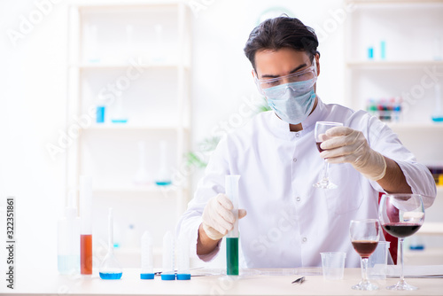 Male chemist examining wine samples at lab