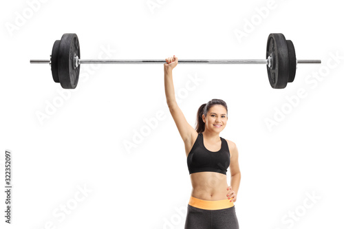 Strong young woman lifting a barbell with one hand