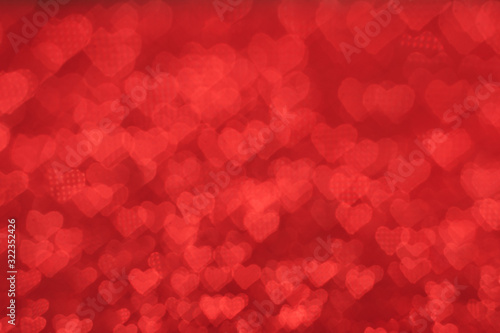 The bokeh texture in the form of many small hearts on a red background. Valentine's day concept.