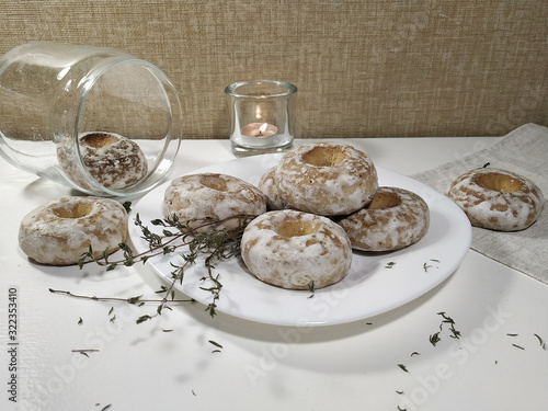 Iced homemade gingerbreads on a white plate in light pastel tones