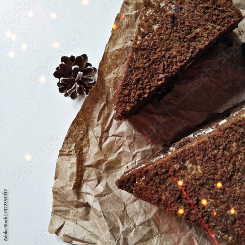 A pieces of chocolate brownie on a crumpled paper with bokeh lights