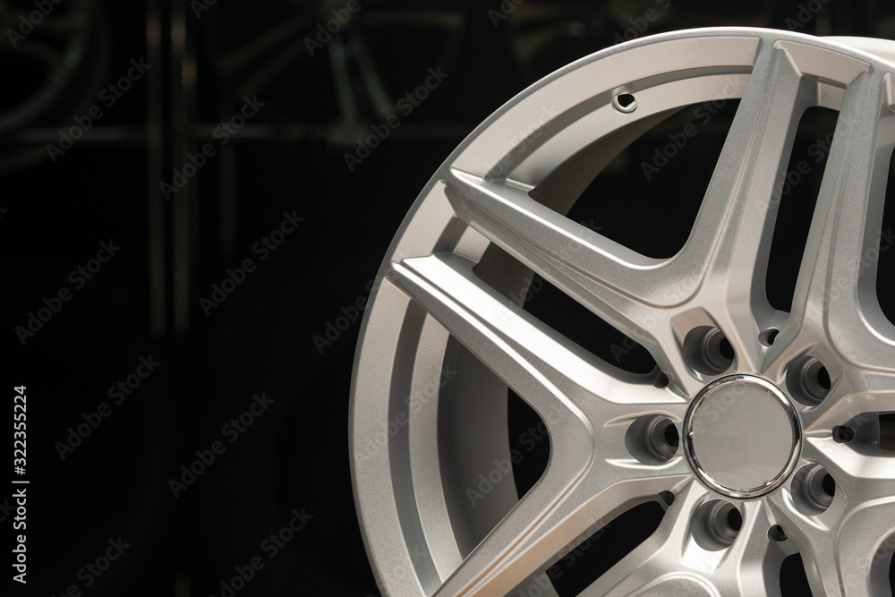 alloy wheel silver, rim new car wheel on a black background close up. Copyspace copy space, front view alloy wheel silver, rim new car wheel on a black background close up. Copyspace copy space, front view