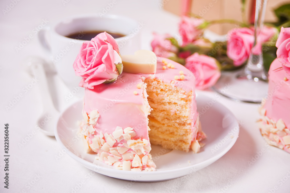 Mini small cake with pink glaze, beautiful roses, cup of coffee, gift box on the white table. Mini small cake with pink glaze, beautiful roses, cup of coffee, gift box on the white table.