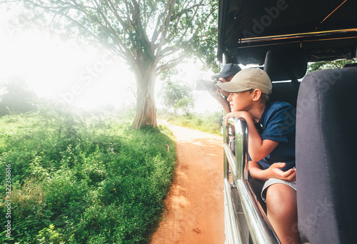 Photography Little expiorer boy portrait with his father taking  of wild animals photos with modern camera with telephotolens as they enjoying auto safari