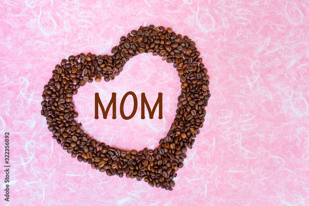 Mother's Day concept. Coffee been with the letter MOM on white pink background. Top view with copy space. Mother's Day concept. Coffee been with the letter MOM on white pink background. Top view with copy space.