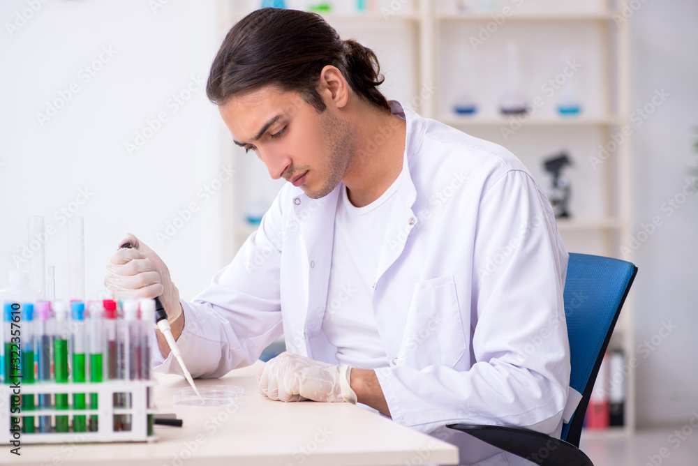 Young male chemist working in the lab Young male chemist working in the lab