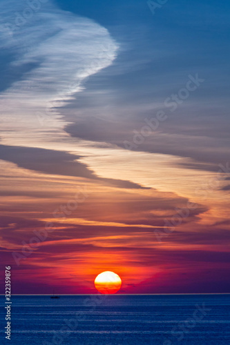 A Mediterranean Greek sunset with clouds, in a colorful sky in Mykonos, Cyclades, Greece 