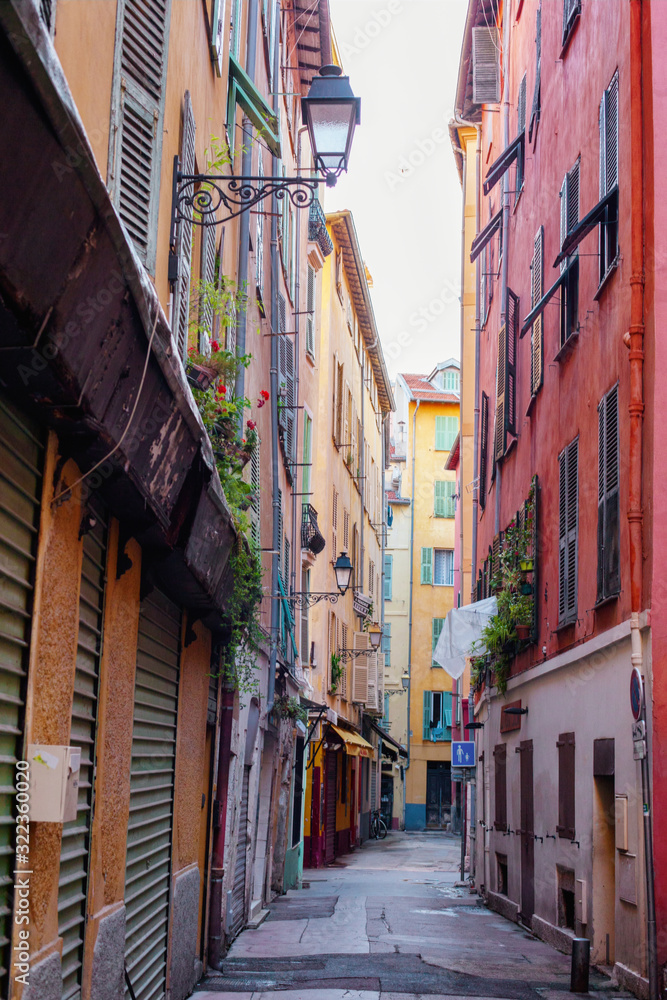 Narrow street in Nice, old colorful buildings in the old town, French Riviera