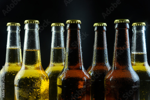 several beer bottles are standing on a black background