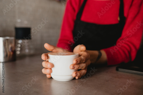Barista is holding a cup of coffee