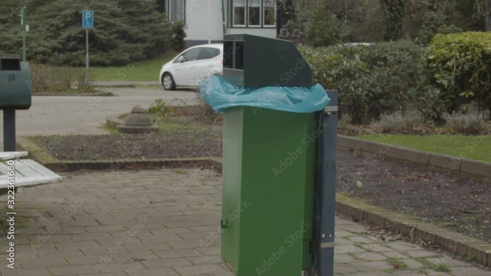 Plastic garbage bag in green trashcan flapping in the wind - slow motion Plastic garbage bag in green trashcan flapping in the wind - slow motion