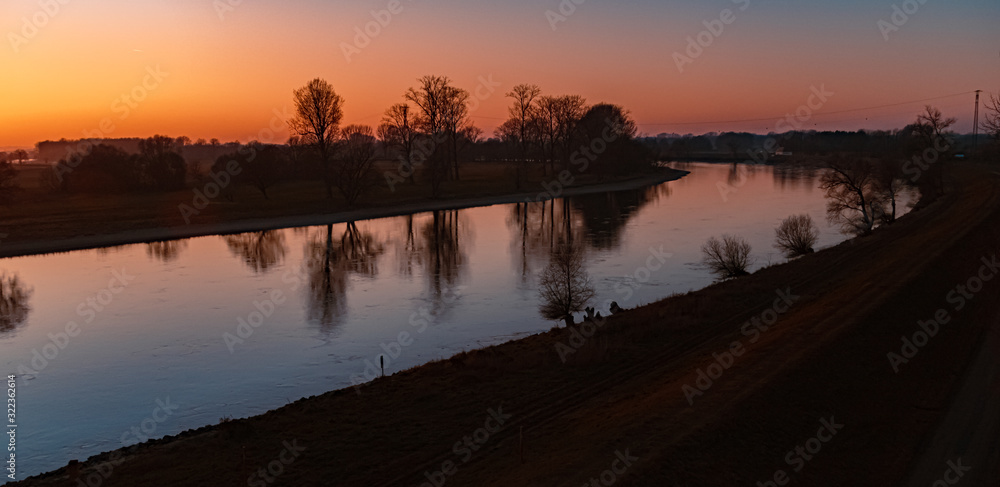 Obraz premium Beautiful sunset with reflections at the river danube near Winzer, Bavaria, Germany