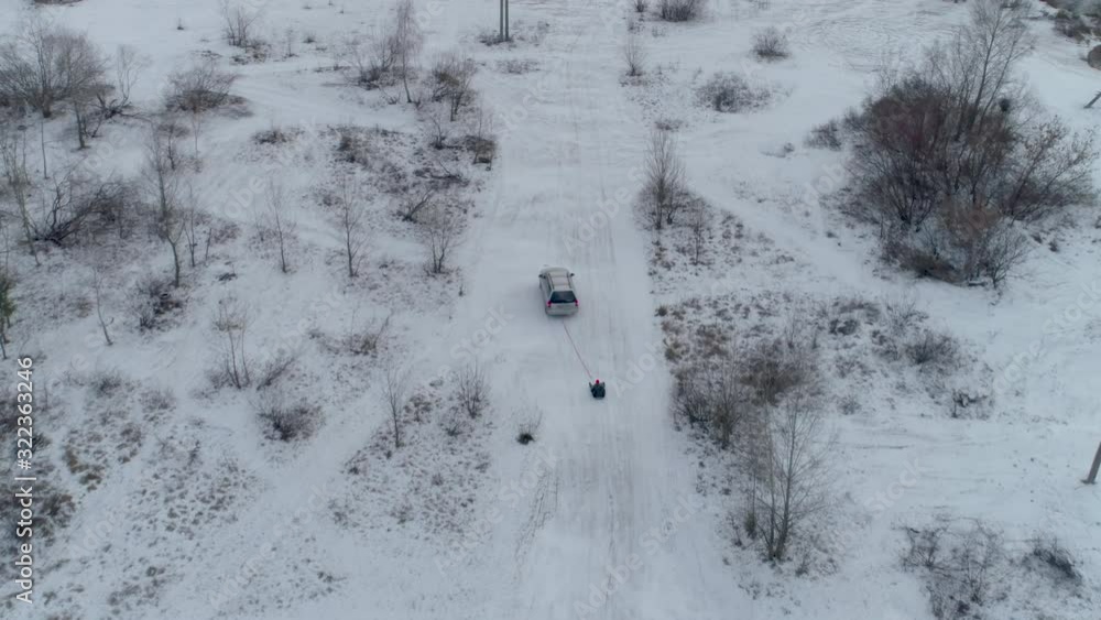 Sledding behind the car 4k aerial. Winter snow and ice. Sledding behind the car 4k aerial. Winter snow and ice.