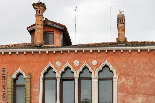 Old facades of houses in Venice, Italy. Characteristic chimneys on the roofs.