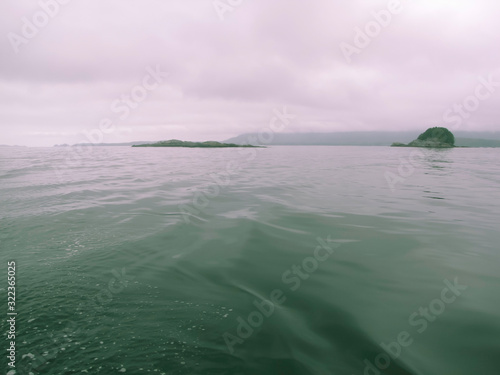 melancholy sea with lslets in fog