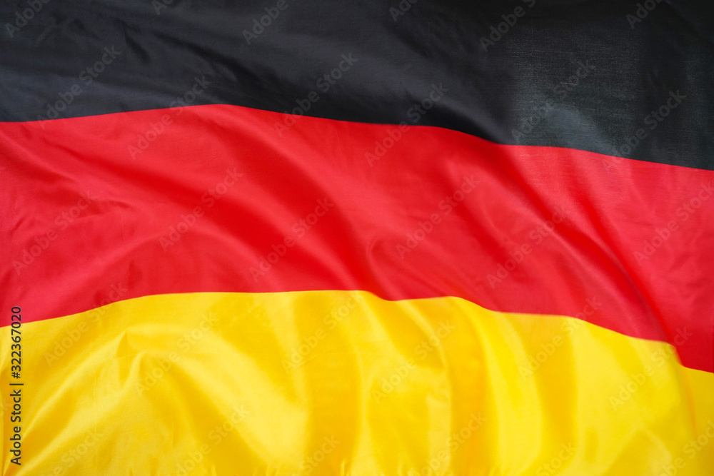Fabric texture flag of Germany. Flag of Germany waving in the wind. Germany flag is depicted on a sports cloth fabric with many folds. Sport team banner. Fabric texture flag of Germany. Flag of Germany waving in the wind. Germany flag is depicted on a sports cloth fabric with many folds. Sport team banner.