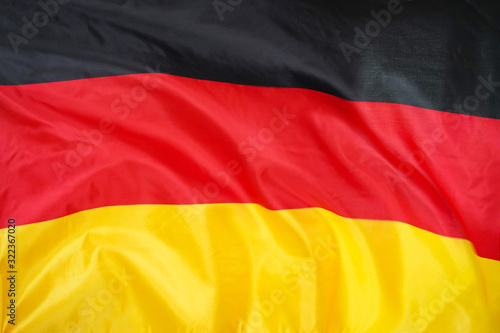 Fabric texture flag of Germany. Flag of Germany waving in the wind. Germany flag is depicted on a sports cloth fabric with many folds. Sport team banner.