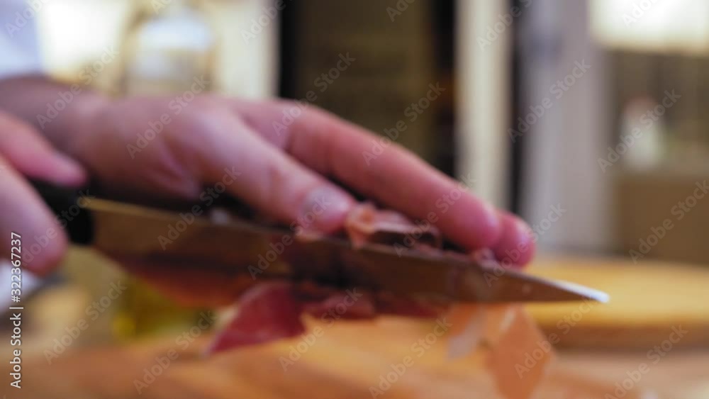 the chef picks up the cut ham from the board. the chef picks up the cut ham from the board.