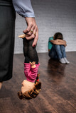 Shooting in the Studio. In the foreground, a woman holds a doll by the legs.  A girl is sitting on the floor.