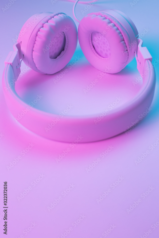 Retro 90s style photo of white stylish wireless headphone in neon lights. Music concept. Retro 90s style photo of white stylish wireless headphone in neon lights. Music concept.