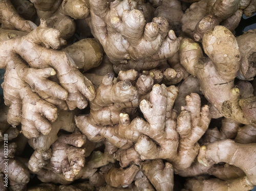 raw root vegetables - medium-sized ginger tubers on a supermarket counter awaiting buyers