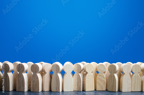 A crowd of wooden figures of people. Customers and buyers, statistics, preferences of Population. group of citizens, rally, political movement or electorate. Society, demography. Employees. Copy space