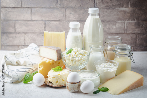 Fresh dairy products, milk, cottage cheese, eggs, yogurt, sour cream and butter on white table