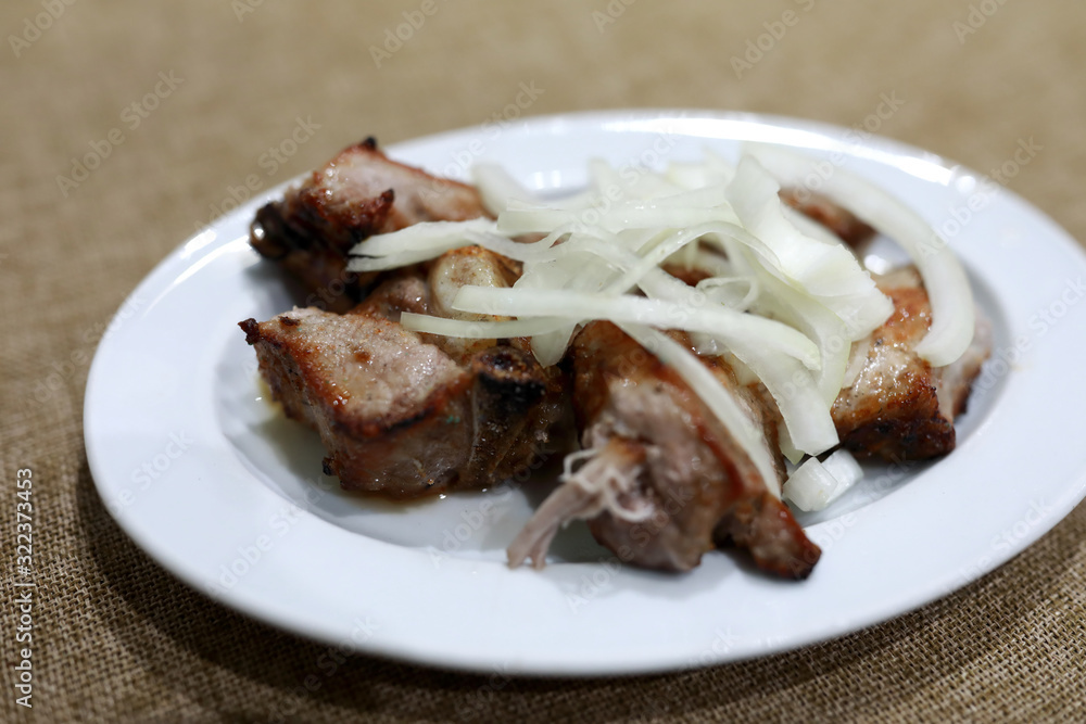 White plate with kebab and onions
