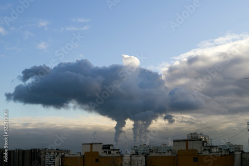 huge smoke from chimneys in the sky above the city © Olga