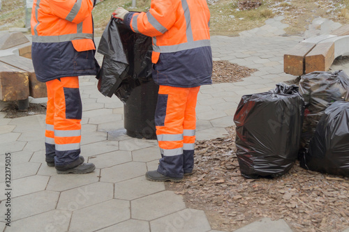 Workers clean up trash on the street.