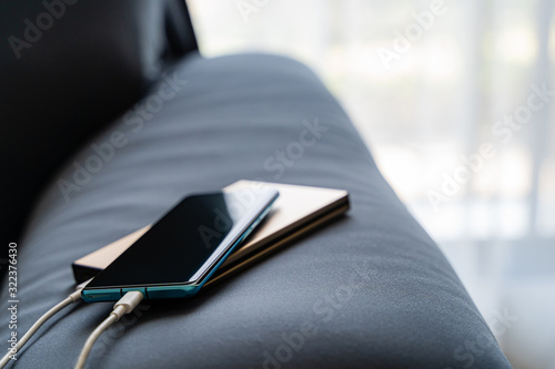 Mobile charging to smartphone from portable charger on Sofa..