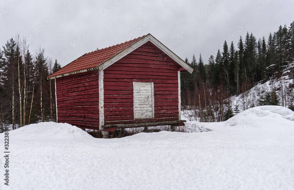 Old traditional Norwegian building surrounded by winter landscape 