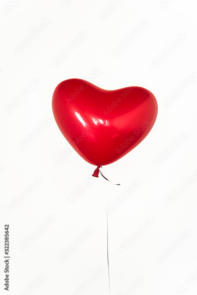 One red balloon shape heart on white background. Vertical picture