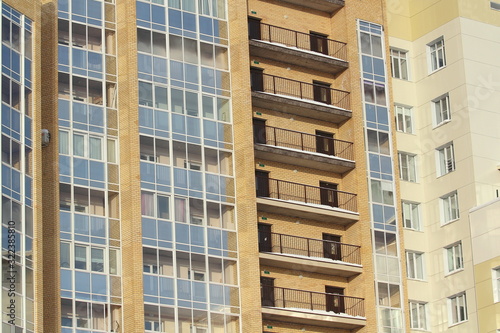 Plastic windows in a modern tiled brick high-rise house.