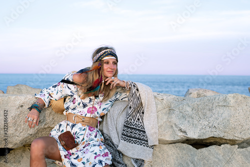 Beautiful woman wearing long dress and accessories boho style. Bohemian style girl on the beach