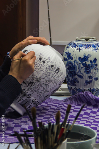 Delft, the Netherlands, Holland,January 18, 2020. The process (stages) of decorating (painting) a traditional blue vase on Royal Delft, the black paint turns traditional blue after baking in the oven