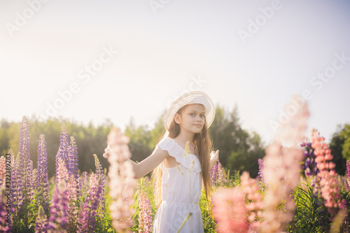 Lovely girl in a white dress in a field of flowers. Copy Space