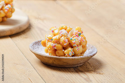 Struffoli napoletani Carnival  italian fritters with honey and sprinkles. photo