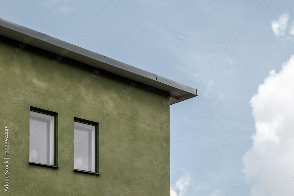 Green house against blue sky