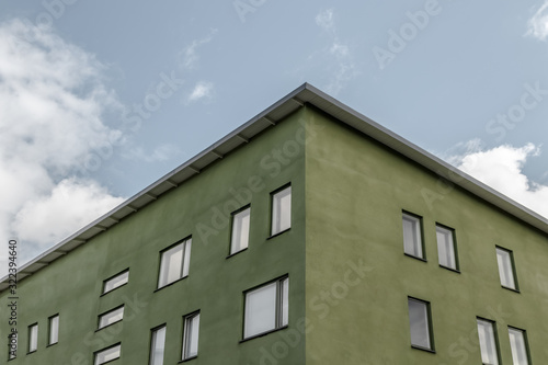 Corner of green building against blue sky