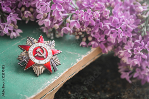 Order, on which is written in Russian - Patriotic War, old books background with lilac, Victory Day 9 May photo