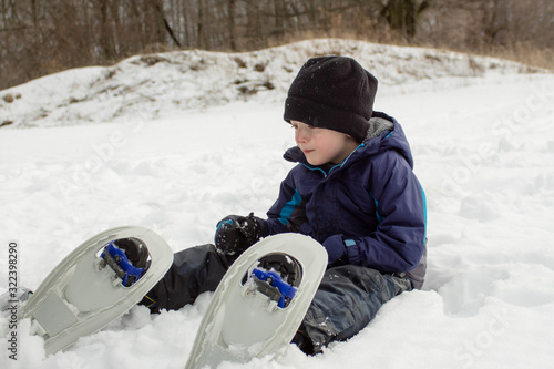 Winter Boy Looking At Snowshoes
