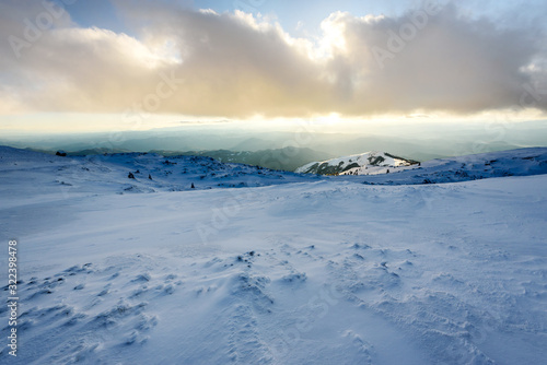 Panorama of winter snowy mountains and sky with sunlit clouds. Kopaonik, Serbia