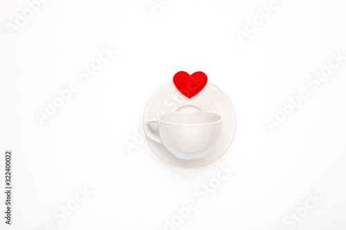 Top view of a white coffee Cup with a heart on a white background. Greeting card for Valentine's Day