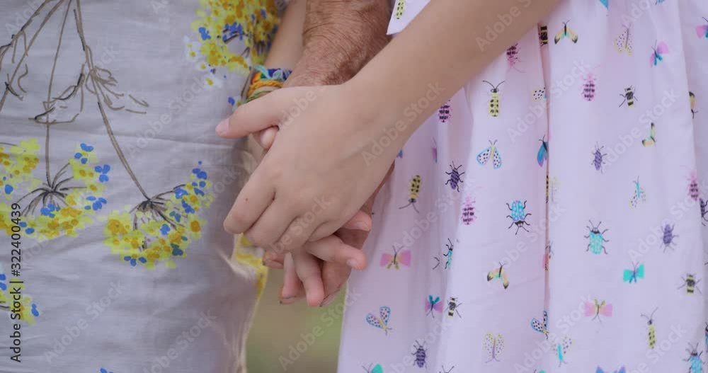 HELPING HAND. Detail of a Child's Hands Holding the Senior Woman Hands HELPING HAND. Detail of a Child's Hands Holding the Senior Woman Hands