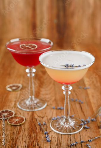 Two fresh cocktail with cream, flower in tall glass on wooden background. Summer cold drink and beverages