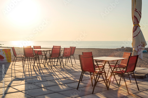 Tables in a restaurant or resort by the sea beach. Restaurant by the sea © spyrakot