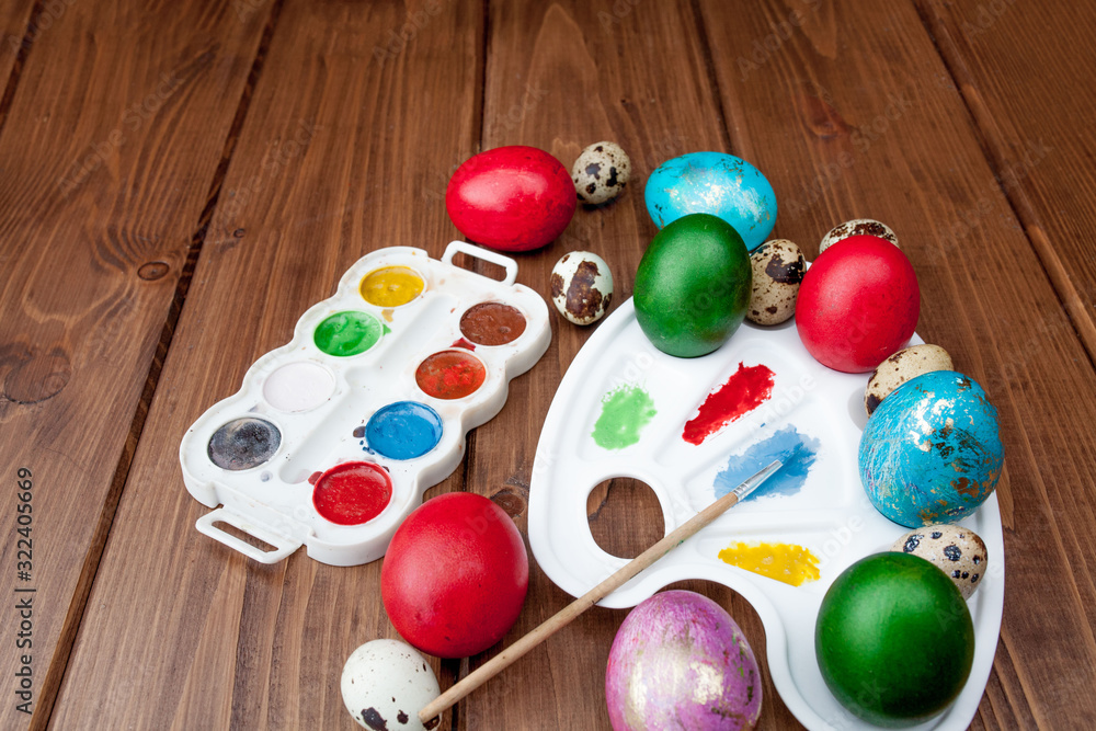 Colored eggs and paint on a wooden table, Easter background