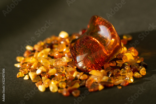 Wallpaper Mural Amber. Many beautiful pieces of red-yellow polished amber with blurred background. Small and large pieces of amber on black background. Side view Torontodigital.ca