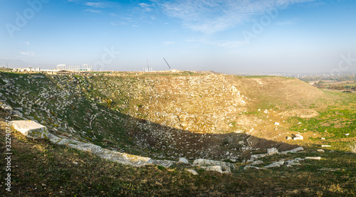 Greek amphitheatre ruins in Laodikion- greek ancient city. Panorama of historical landmark in Turkey with cranes  in the background. Construction site. 2019.11.28. photo